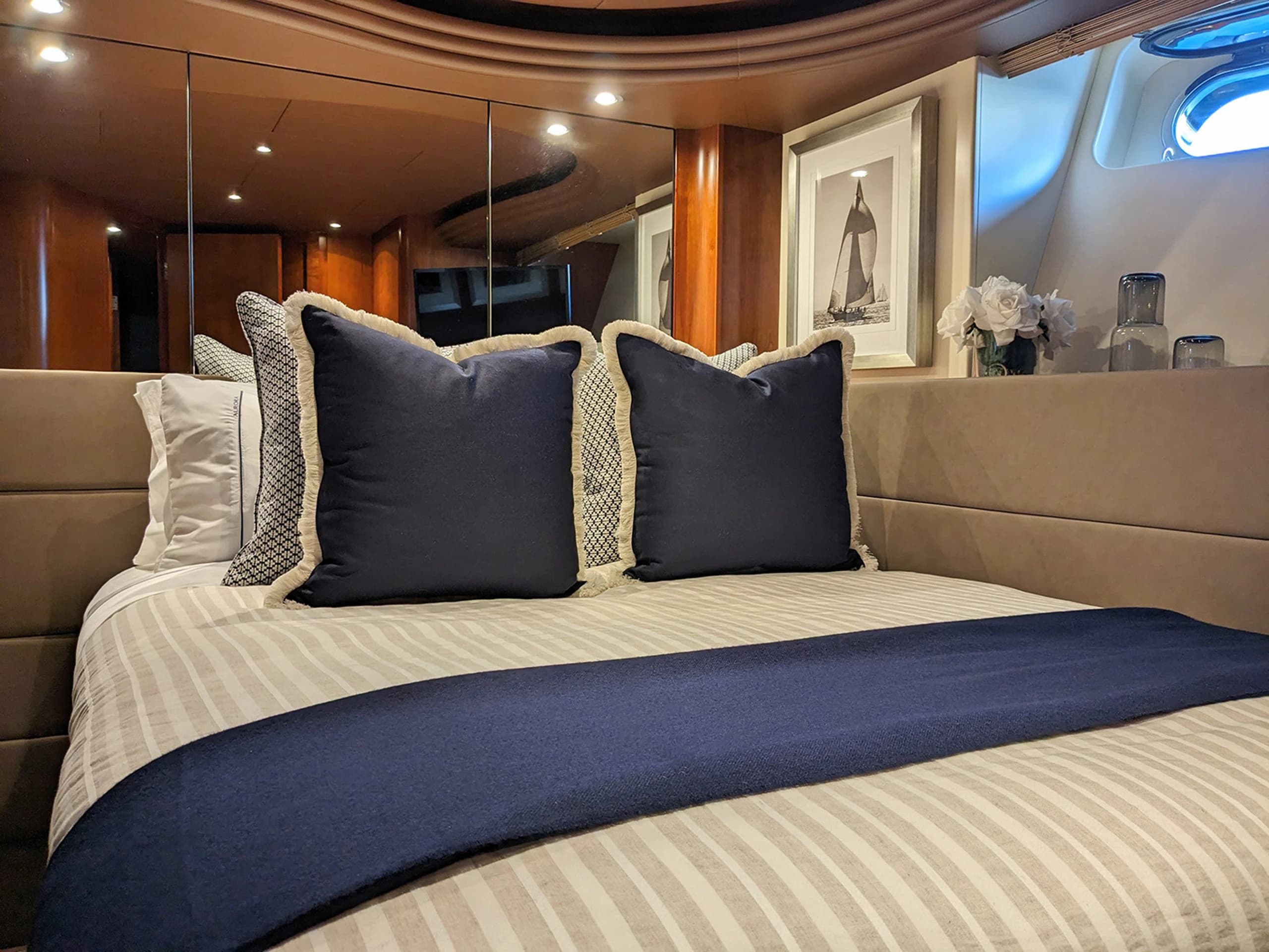 Primary stateroom with centered bed and timber joinery aboard AURORA