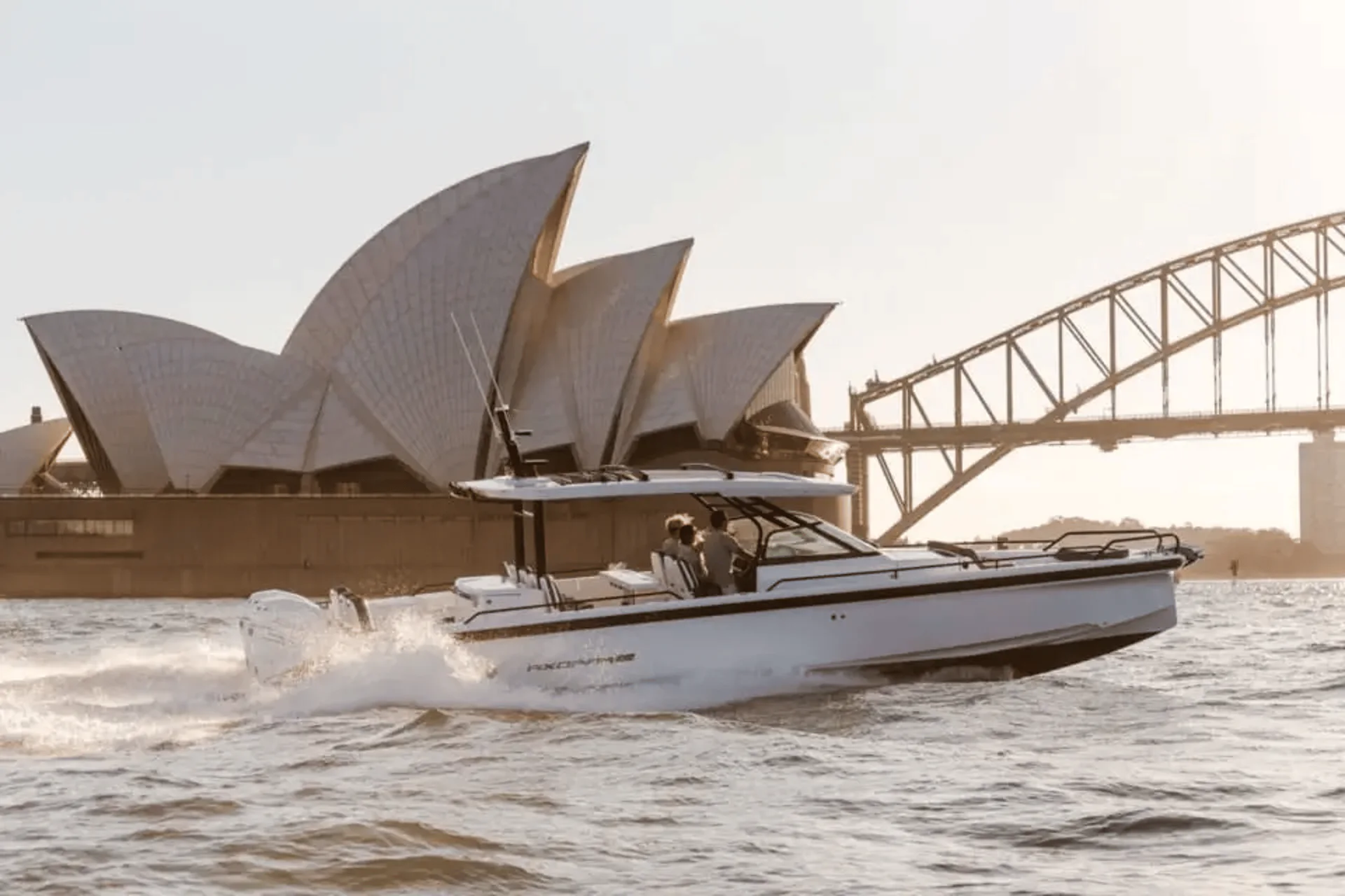 Cheeky II underway on Sydney Harbour with the Sydney Opera House and Harbour Bridge behind.