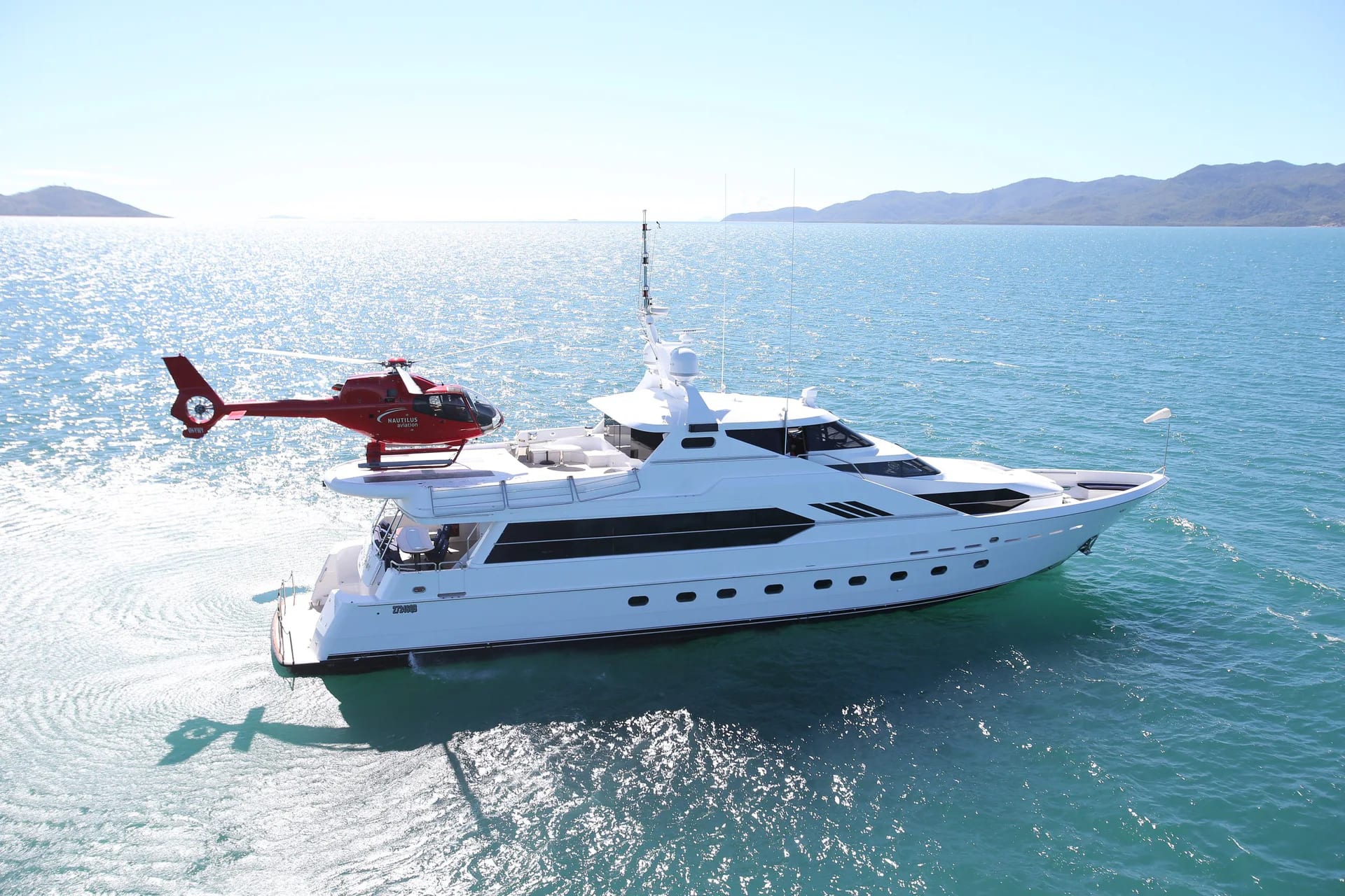 Flying Fish on the water with a red helicopter positioned on the upper deck.