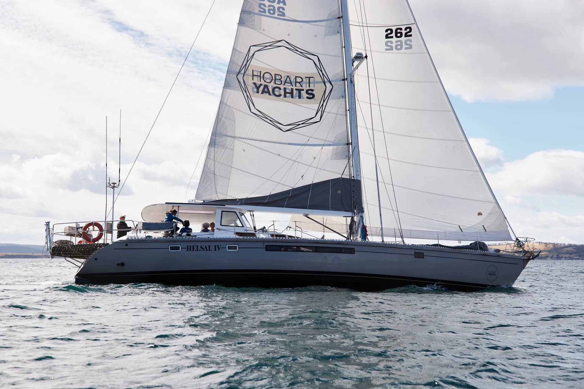 Helsal IV under sail in calm Tasmanian water.