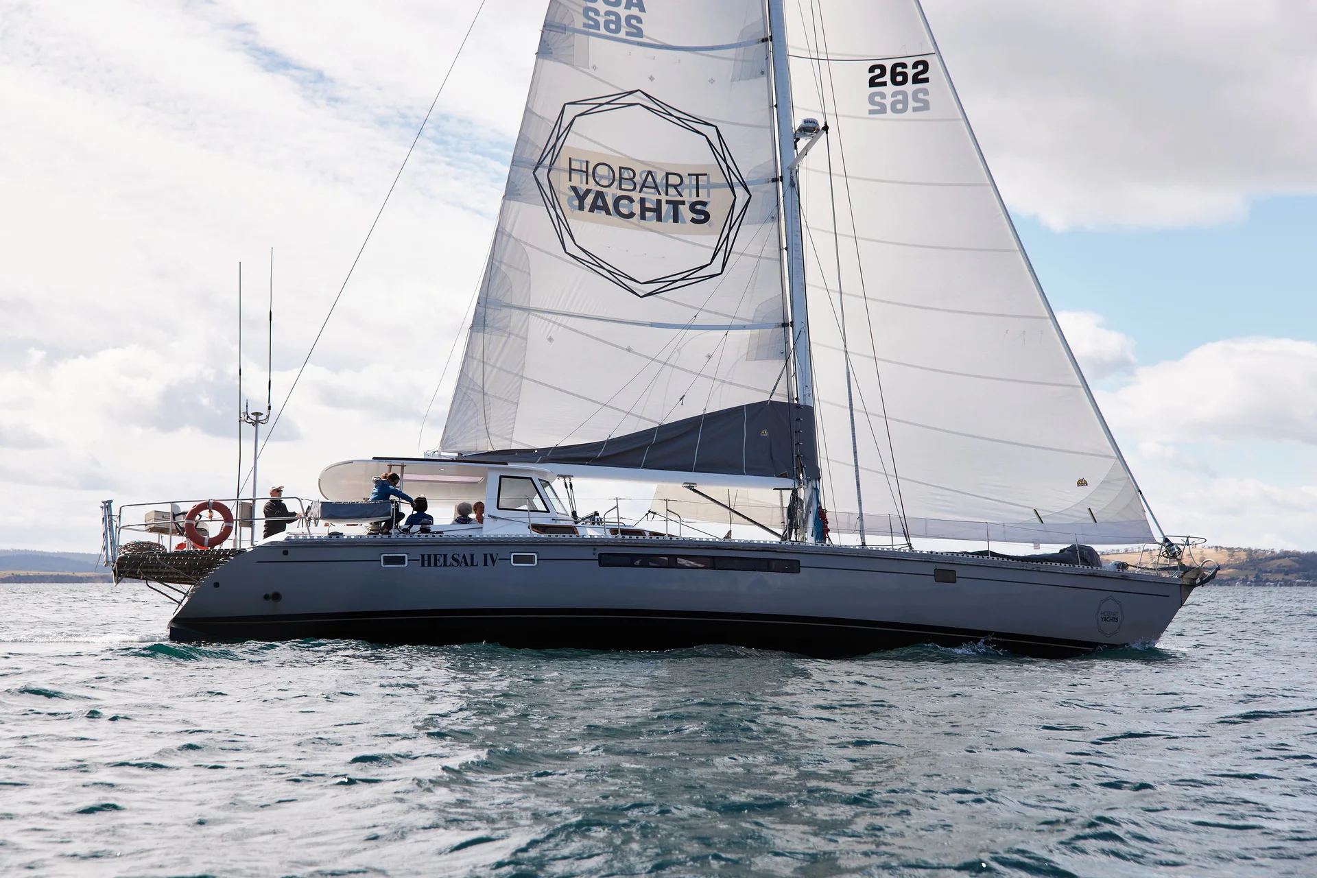 Helsal IV under sail in calm Tasmanian water.