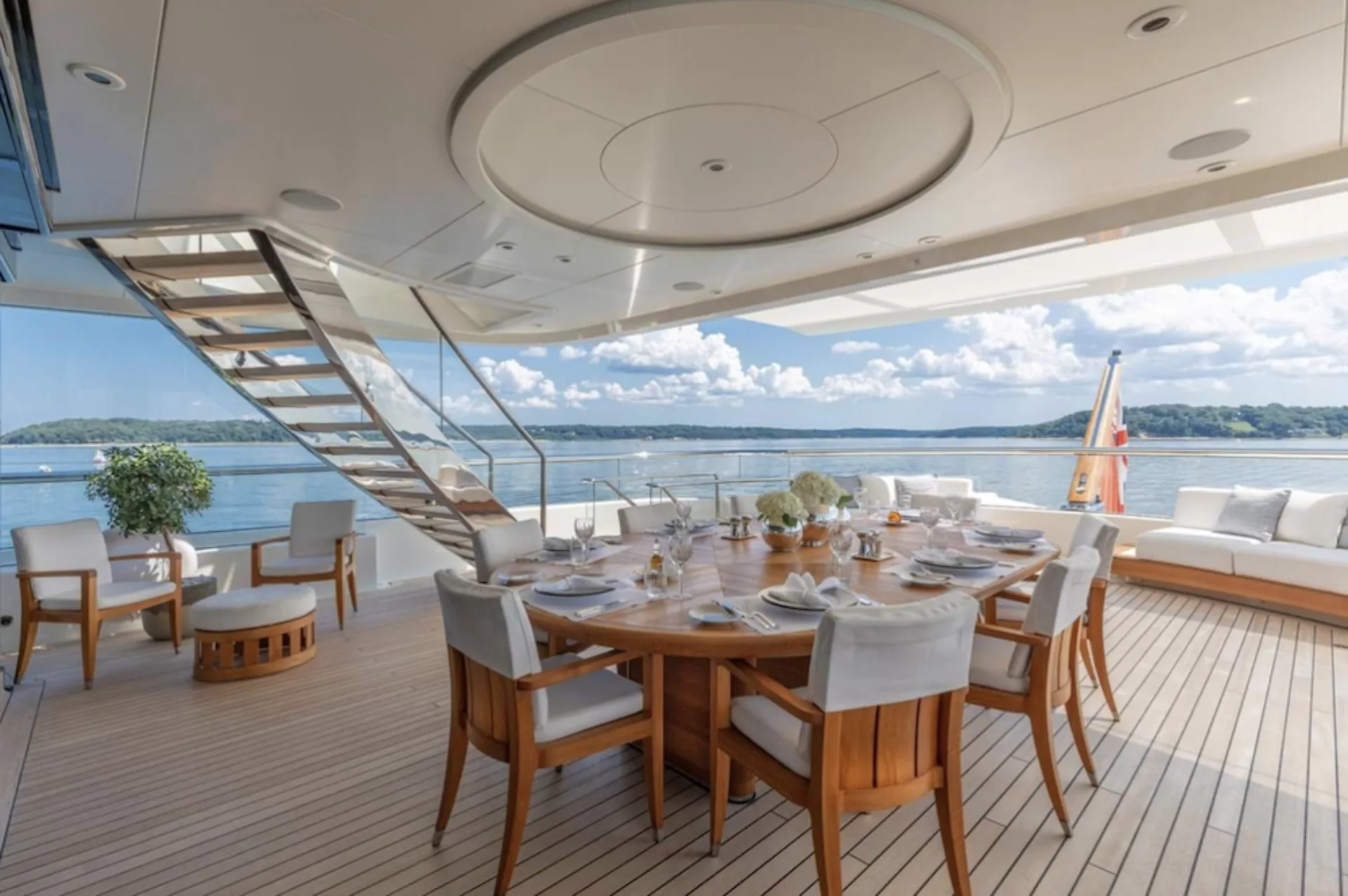 Lunasea's aft-deck dining table beside a wooded shoreline