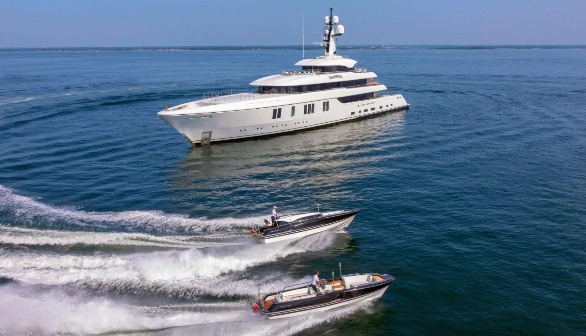Lunasea underway at sea with two tenders alongside.